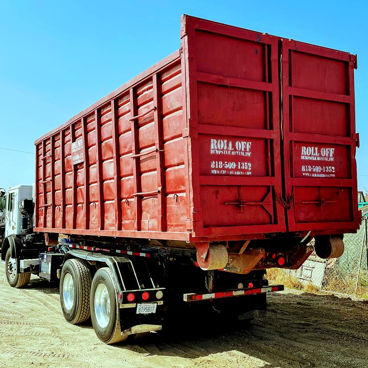 Close view of a 40-yard red roll-off dumpster loaded on a truck