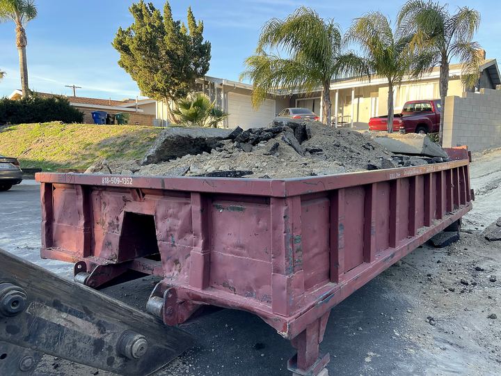 Roll-off dumpster loaded with asphalt and concrete from a Los Angeles driveway tear-out