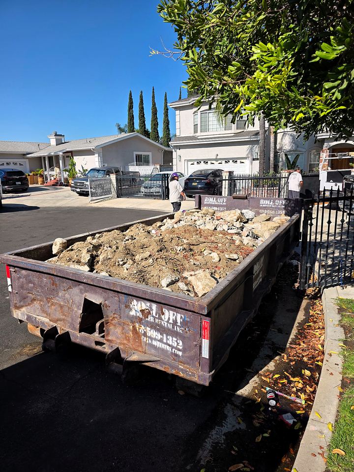 Lowboy dumpster loaded with concrete rubble outside a Los Angeles residence