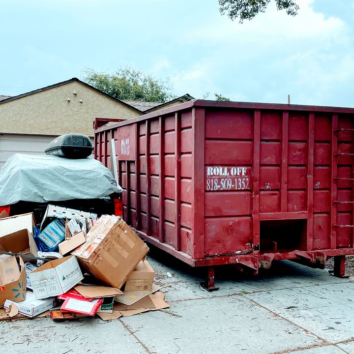 Roll-off dumpster loaded with household junk and furniture from a Los Angeles home cleanout