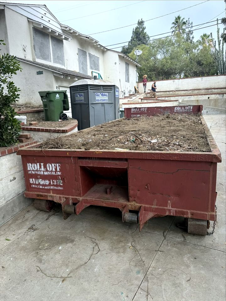 10-yard lowboy roll-off dumpster loaded with dirt from a Los Angeles yard excavation